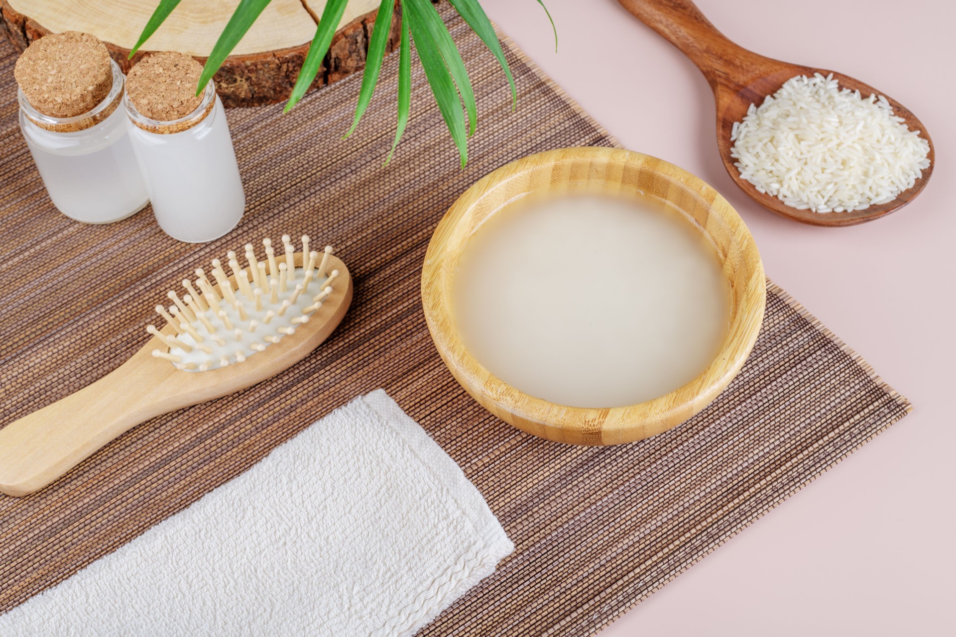 Homemade cosmetic rice water with ingredients on beige background, copy space